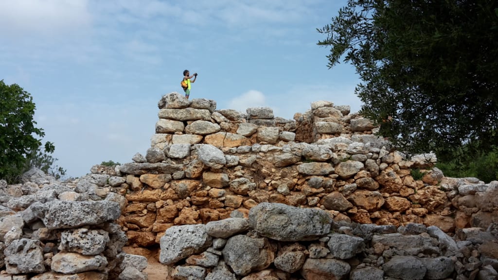 Rovine antiche in pietra tra la vegetazione mediterranea a Maiorca.